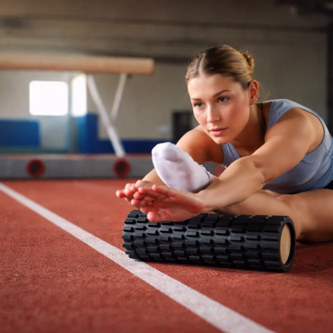 Foam roller zwart grid gebruikt tijdens stretching en spierherstel in sportschool